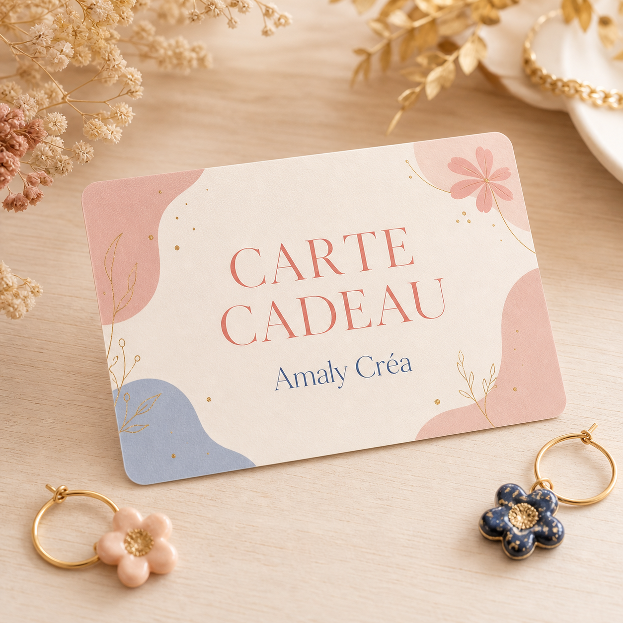 Carte cadeau Amaly Créa entourée de boucles d’oreilles florales faites main
